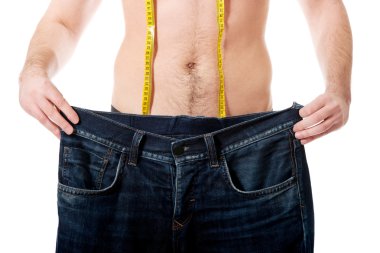 Adam büyük boy kot pantolon ve ölçü birimi teyp ile.