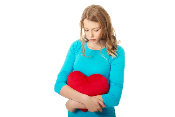 Woman with heart shaped pillow — Stock Photo, Image