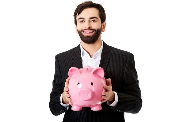 Empresário que detém um Piggy Bank. — Fotografia de Stock