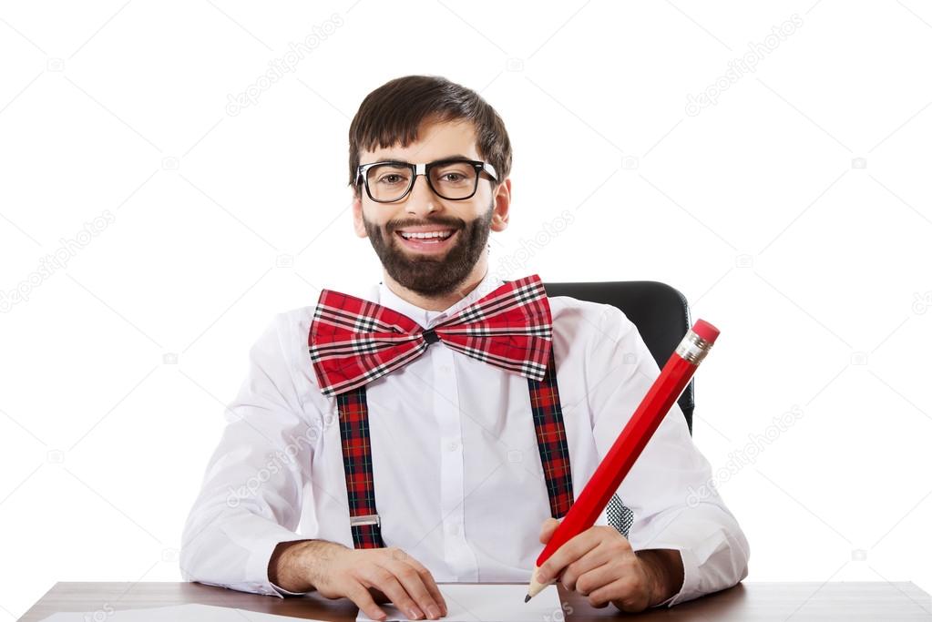 Young man writing with big pencil.