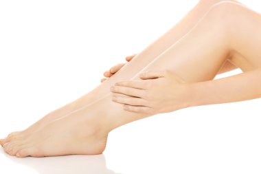 Bacağına masaj yapan bir kadın.