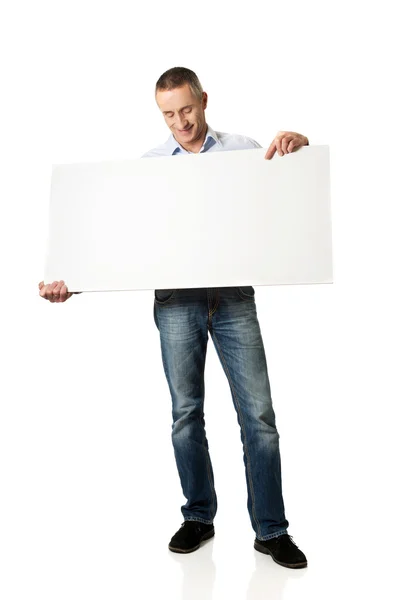 Przystojny mężczyzna trzymając pusty transparent — Zdjęcie stockowe