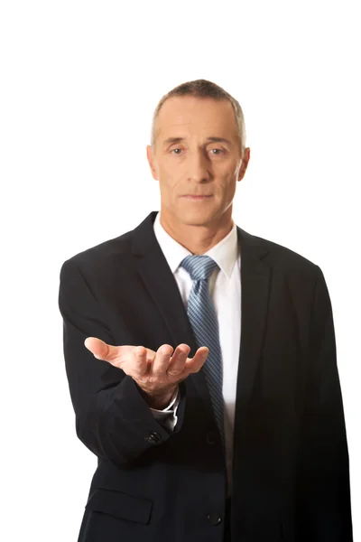 Businessman holding something on his palm — Stock Photo, Image