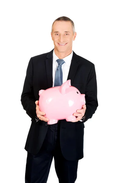 Alegre hombre de negocios sosteniendo Piggybank — Foto de Stock