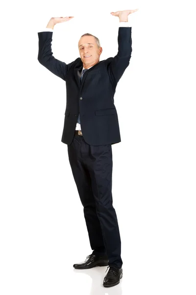 Businessman pushing invisible ceiling — Stock Photo, Image