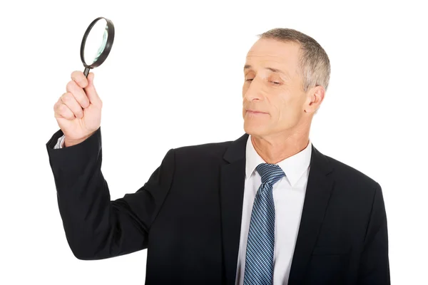 Businessman with a magnifying glass — Stock Photo, Image