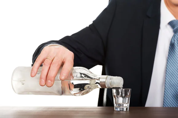 Mano masculina vertiendo vodka en un vaso — Foto de Stock