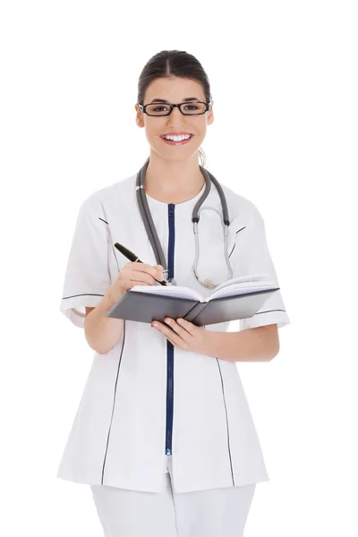 Médica mulher escrevendo em seu caderno — Fotografia de Stock