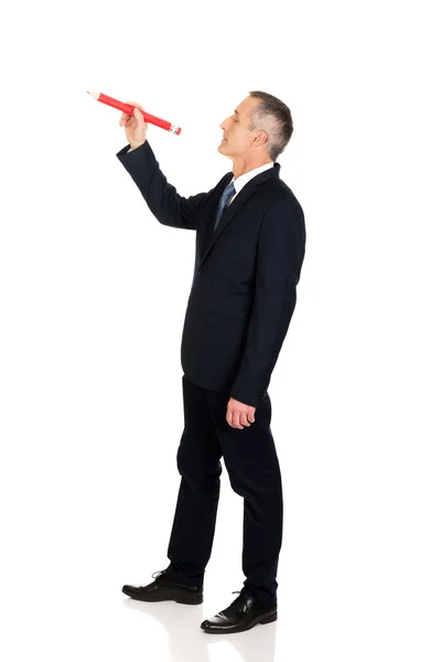 Бизнесмен с большим красным карандашом — стоковое фото
