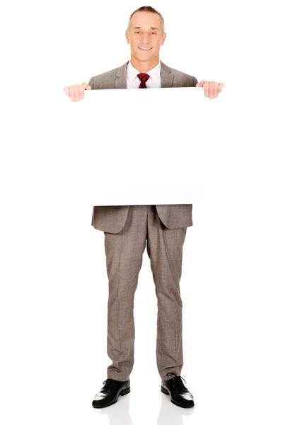 Businessman holding empty banner — Stock Photo, Image