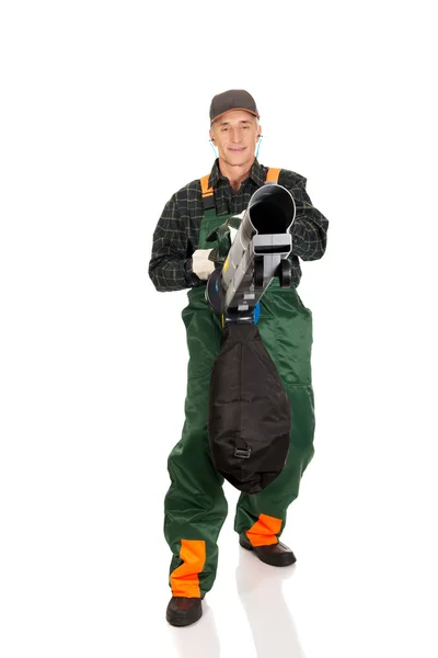 Jardineiro em uniforme com um ventilador de folha — Fotografia de Stock