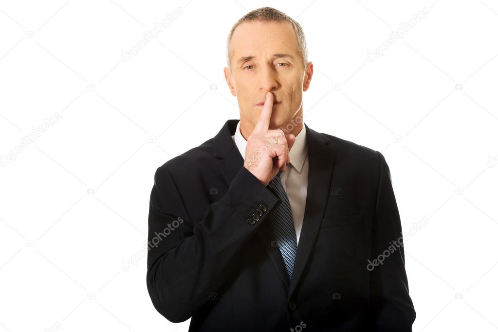 Businessman gesturing silent sign
