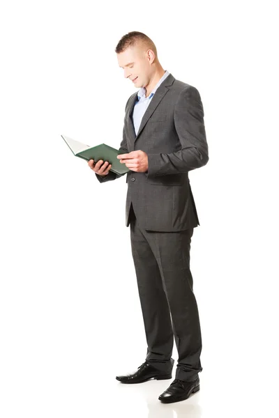 Empresario leyendo su cuaderno —  Fotos de Stock