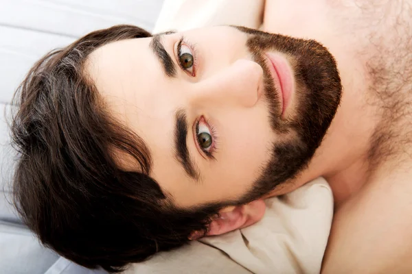 Muscular man lying in bed. — Stock Photo, Image