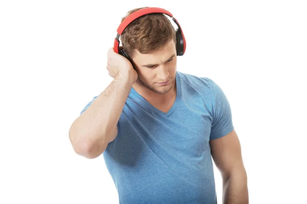 Knappe man die naar muziek luistert met een koptelefoon. — Stockfoto