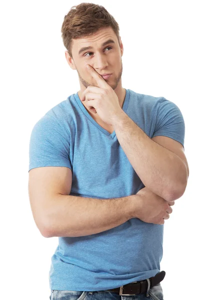 Young thoughtful man with finger under chin. — Stock Photo, Image