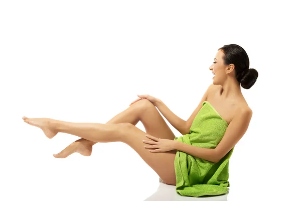Mujer envuelta en toalla con las piernas arriba — Foto de Stock