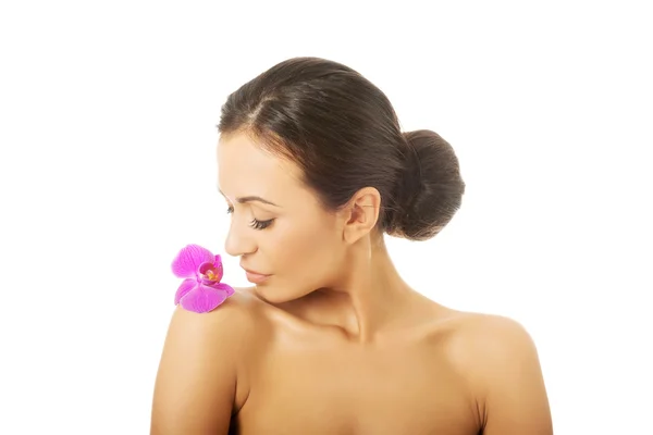 Femme avec pétale d'orchidée pourpre sur l'épaule — Photo