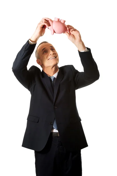 Feliz hombre de negocios sosteniendo Piggybank — Foto de Stock