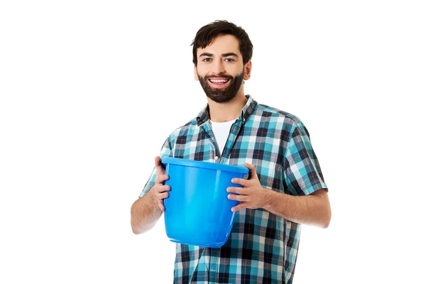 Bonito homem segurando balde de plástico . — Fotografia de Stock