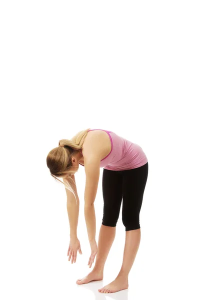 Mujer joven en pose de yoga doblado . —  Fotos de Stock