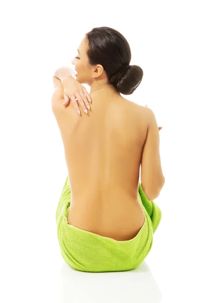 Back view woman sitting wrapped in towel Stock Photo