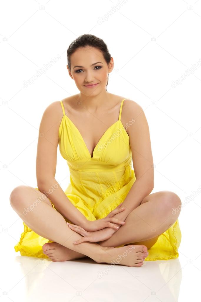 Beautiful woman sitting in yellow dress.