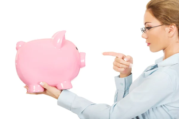 Woman pointing on piggy bank. — Stock Photo, Image