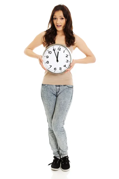 Mujer conmocionada sosteniendo reloj grande . —  Fotos de Stock