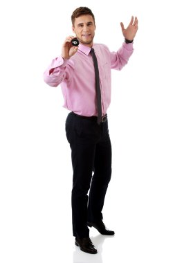 Bilardo topu tutan genç işadamı.