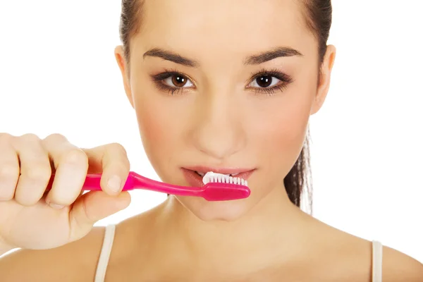 Mujer joven cepillándose los dientes. — Foto de Stock