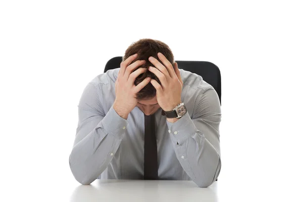 Geschäftsmann sitzt im Büro am Schreibtisch. — Stockfoto