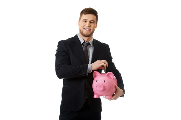 Holding egy piggybank üzletember. — Stock Fotó