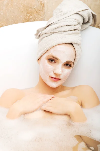 Frau entspannt sich mit Gesichtsmaske. — Stockfoto