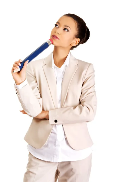 Thoughtful businesswoman with big pencil. — Stock Photo, Image