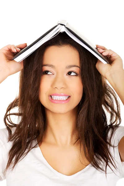Estudante mulher com um livro na cabeça . — Fotografia de Stock