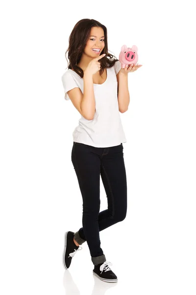 Kvinna som pekar på piggybank. — Stockfoto