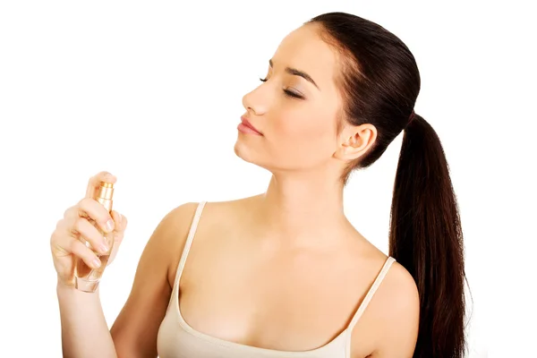 Jovem mulher aplicando parfume . — Fotografia de Stock