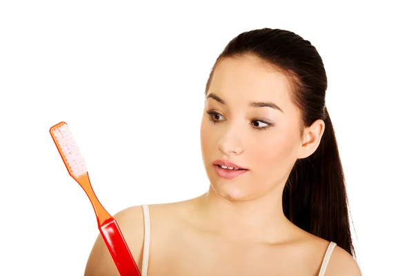 Shocked woman holding big toothbrush. — Stock Photo, Image