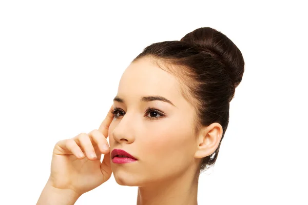 Vrouw met volledige make-up gezicht aan te raken. — Stockfoto