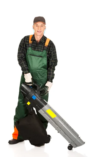 Trabajador en uniforme con un soplador de hojas — Foto de Stock