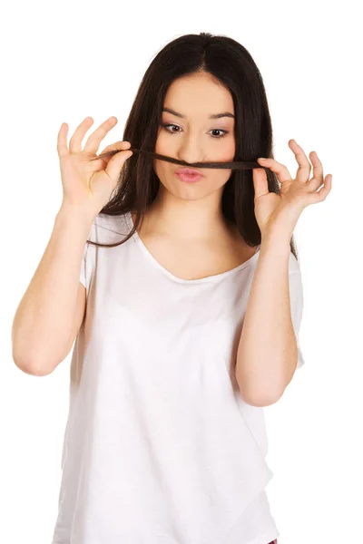 Mulher adolescente colocando o cabelo como bigode . — Fotografia de Stock