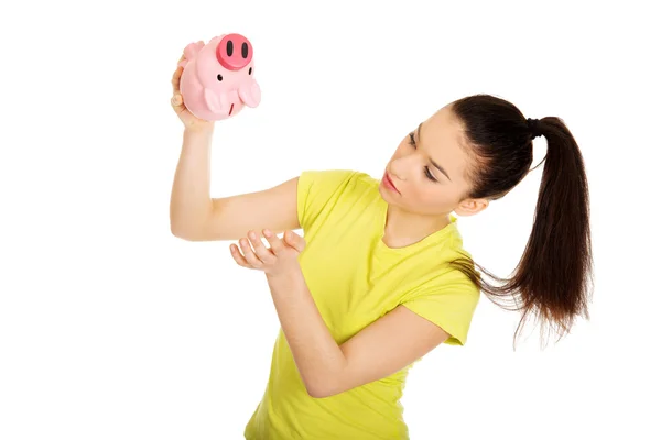 Unglückliche Frau schüttelt Sparschwein. — Stockfoto