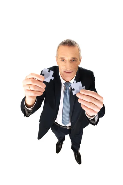 Businessman trying to connect puzzle pieces. — Stock Photo, Image