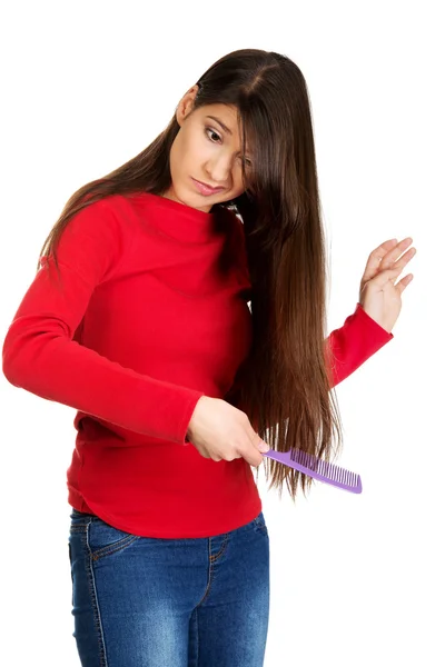 Mulher penteando seu cabelo emaranhado . — Fotografia de Stock