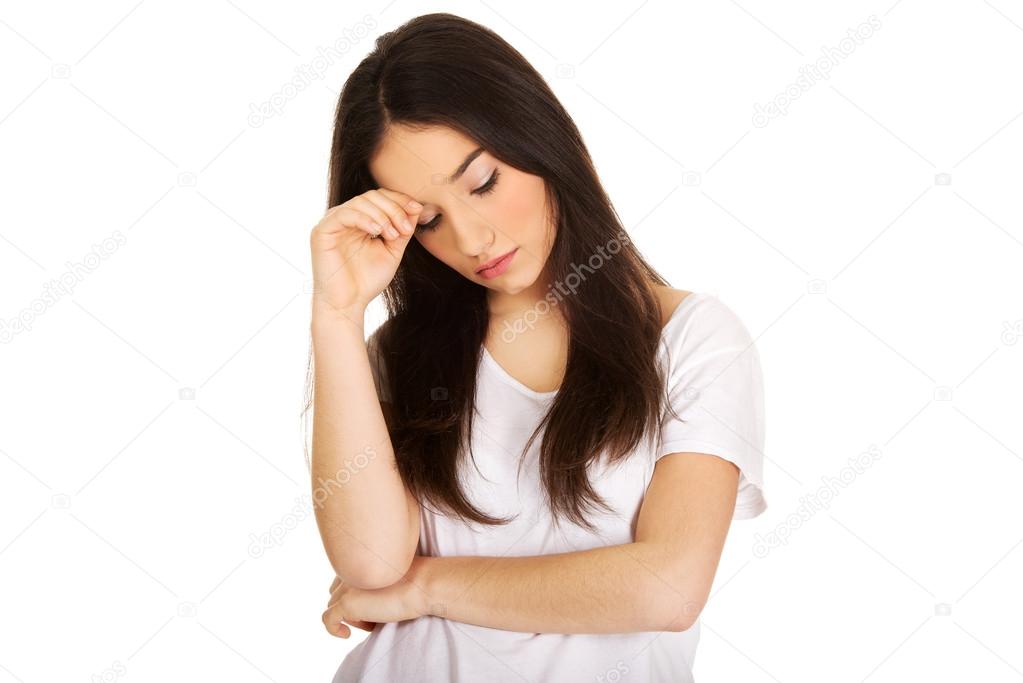 Depressed teen woman touching head.