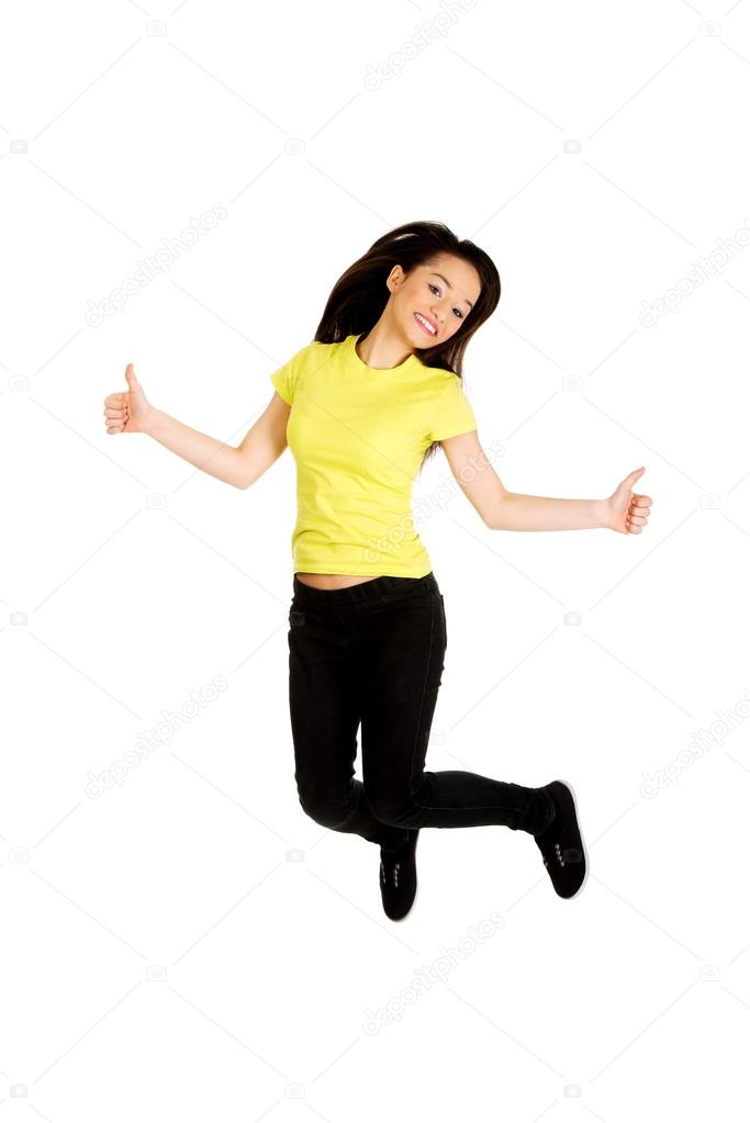 Happy woman jumping with thumbs up.