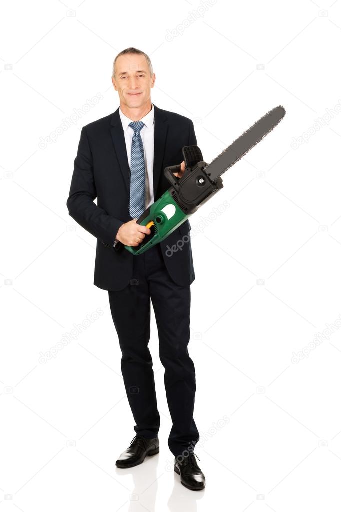 Smiling businessman with chainsaw