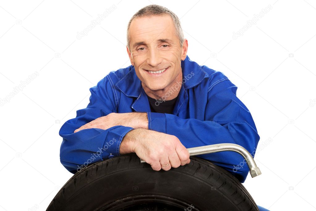 Happy mechanic with a tire and wrench