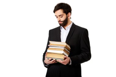 Genç işadamı kitap yığını tutan.